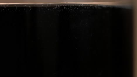 close-up of a dark carbonated drink in a glass