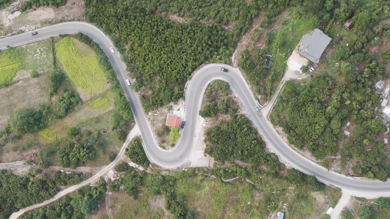 알바니아의 serpentine mountain road에서 자동차를 운전하는 공중에서 내려갑니다.