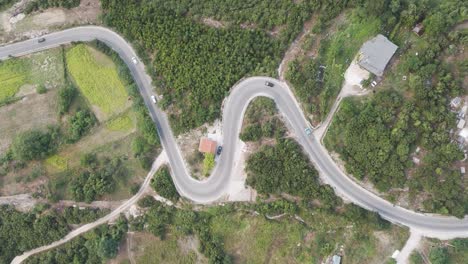 desciende desde el aire sobre los coches que conducen por la carretera de la montaña serpentine en albania