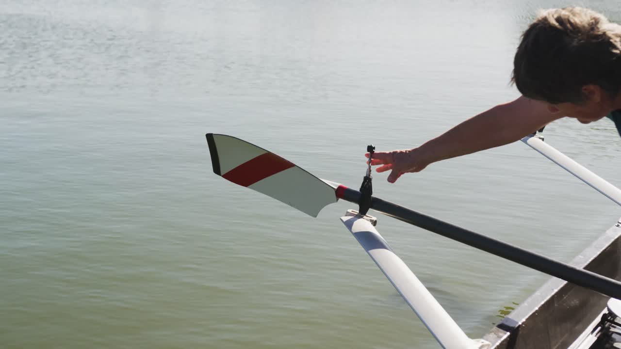 Senior caucasian woman preparing rowing boat in a river