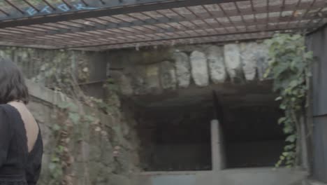 Young-woman-with-dark-clothes-dancing-in-front-of-camera-from-inside-an-abandoned-prison