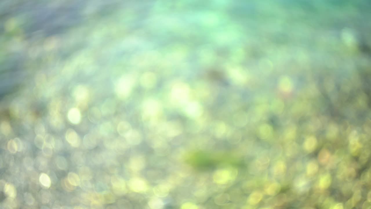 hermosa textura brillante y brillante de agua azul borrosa con el sol reflejado en la superficie del agua