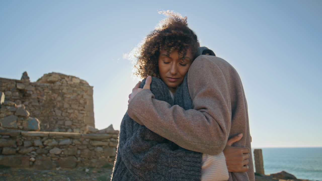 Young couple cuddling together at sunny day closeup. Mixed race people hugging