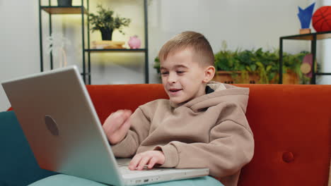 Amazed-teen-boy-use-laptop-computer,-receive-good-news-message,-shocked-by-victory,-celebrate-win