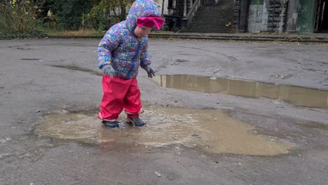 toddler girl playing in puddle