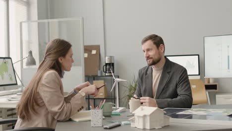 woman and man talking about renewable energy project in the office 1