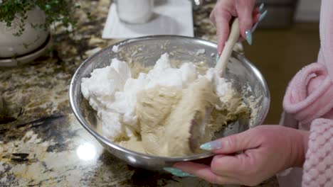 folding beaten egg whites into a dough mixture to make danish aebleskivers - aebleskiver series