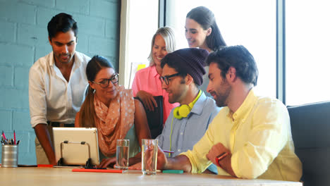 Businesspeople-having-a-discussion-while-using-digital-tablet