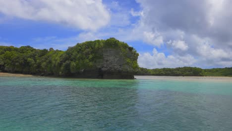 Scene-of-Kabira-Bay's-beauty-in-Ishigaki,-highlighting-rocky-islands,-sandy-beaches,-and-tourist-vessels-near-the-water