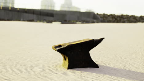 blacksmithing tools left on sandy beach during sunset near city skyline