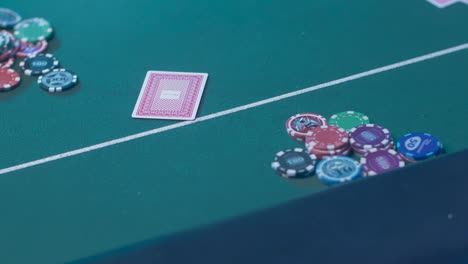 Ausgeschnittene-Ansicht-Der-Hände-Einer-Casino-Händlerin,-Die-Spielkarten-Auf-Dem-Grünen-Tisch-Verteilt