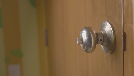 a hand turning a door knob