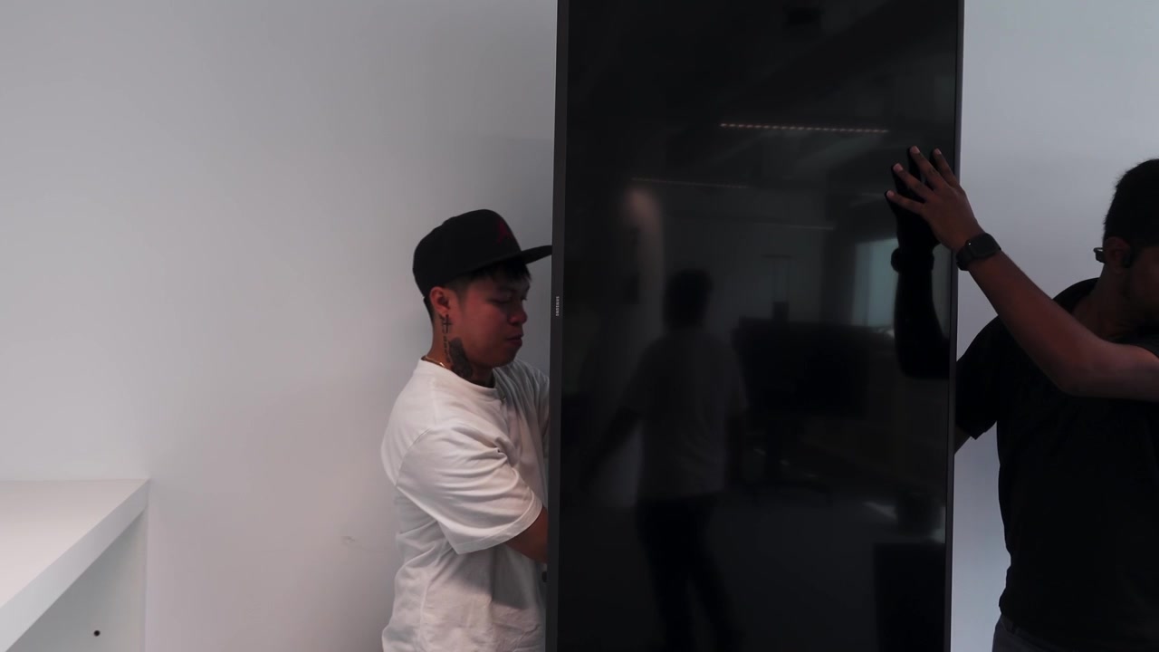 Men setting up a screen on a stand in portrait format