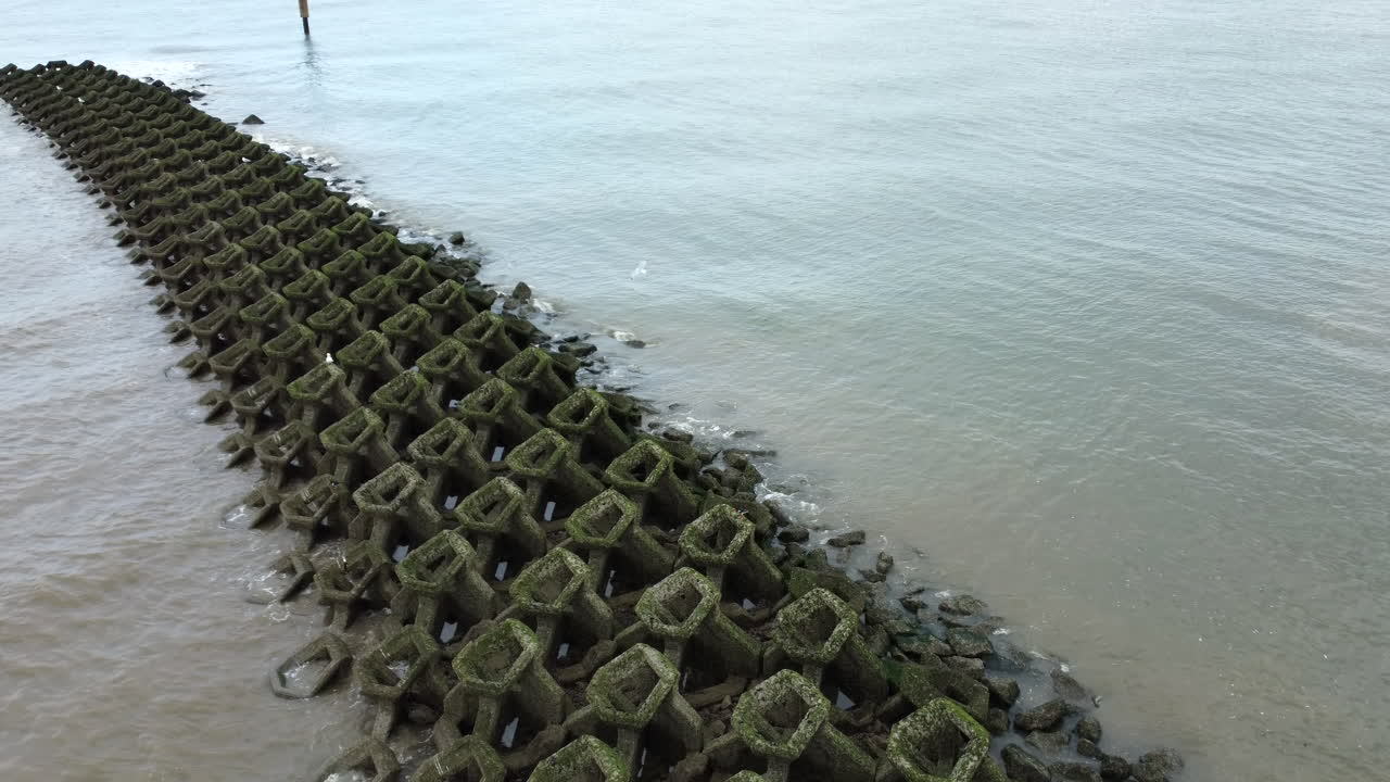 Dronebillede i fugleperspektiv af New Brighton Beach med bølgebrydere
