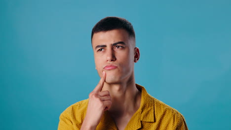 a thoughtful man in a yellow shirt contemplating
