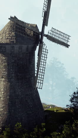 ancient stone windmill in a misty landscape