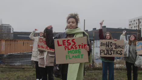 young american female activist holding a cardboard placard against the use of plastics during a climate change protest 1