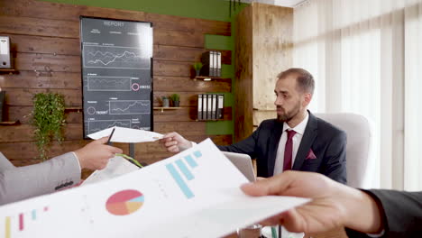 businessman in suit giving his colleague finacial charts