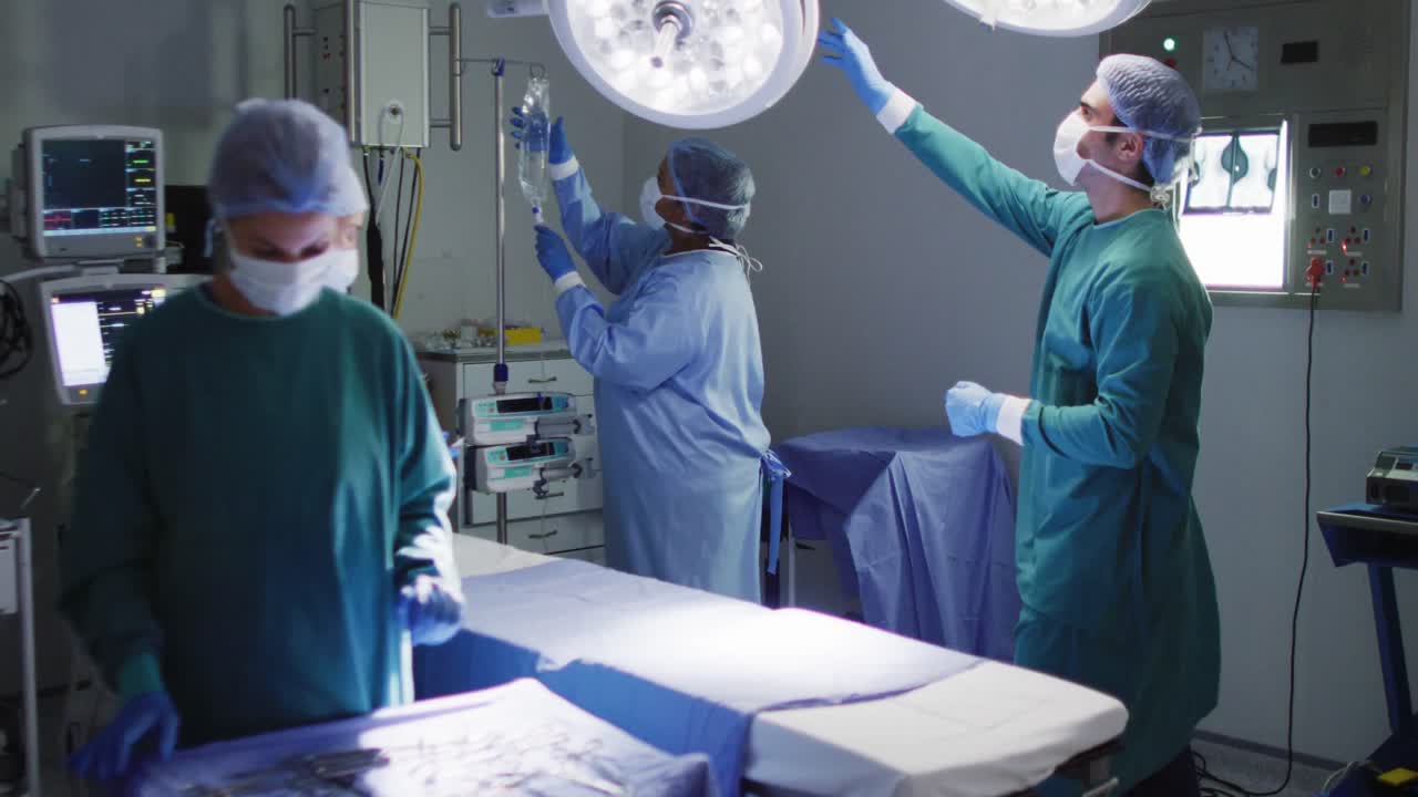 video de un grupo diverso de cirujanos y asistentes quirúrgicos preparando el quirófano para la operación