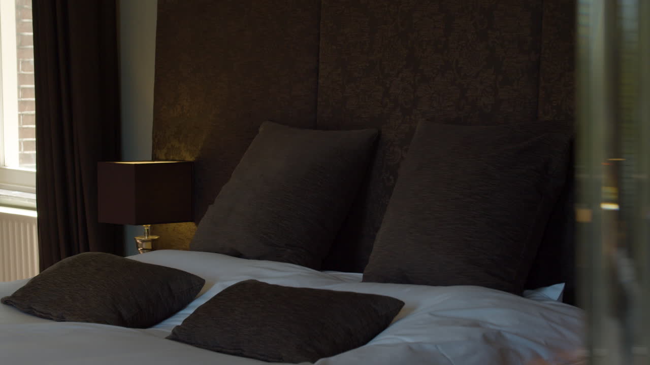 Revelación con dolly del cabecero de una cama doble en una hermosa habitación de hotel - primer plano.