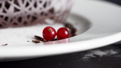 a person catches a cherry from a plate for decoration, close up shot, insert shot