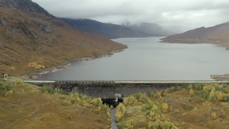 Eine-Luftaufnahme-Des-Cluanie-Staudamms-Am-Loch-Cluanie-Im-Nordwestlichen-Hochland-Von-Schottland-Am-SE-Ende-Von-Glen-Shiel-An-Einem-Bewölkten-Tag