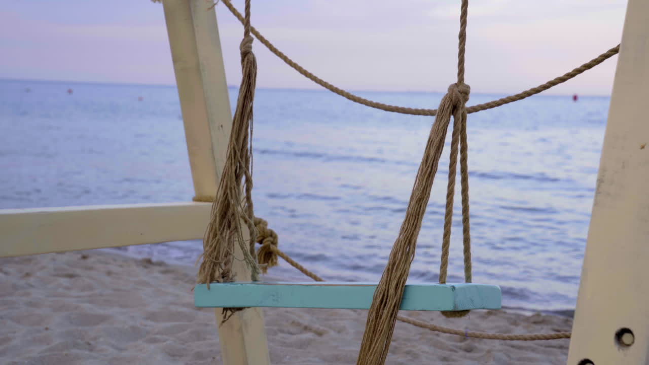 Altalena sulla spiaggia al tramonto
