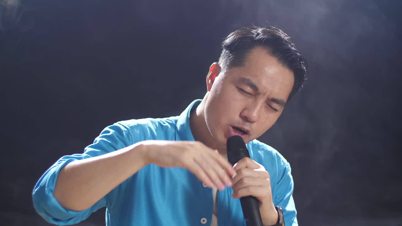 무대에서 마이크로 노래하는 남자