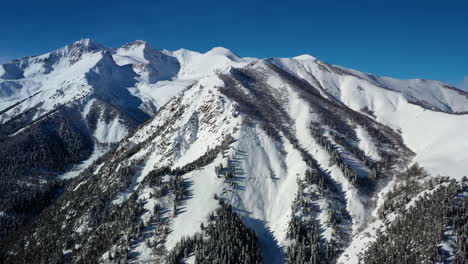 air flight through mountain clouds over beautiful snow-capped peaks of mountains and glaciers.