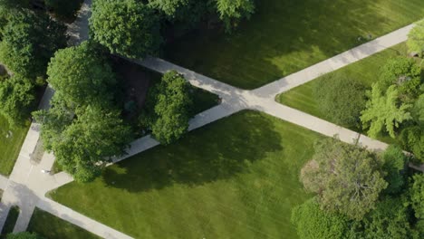 Vista-De-Arriba-Hacia-Abajo-Del-Campus-Universitario-Con-Césped-Común,-Senderos-Para-Caminar-Y-Hermosos-árboles-Verdes