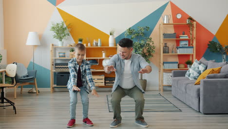 father and son dancing in the living room