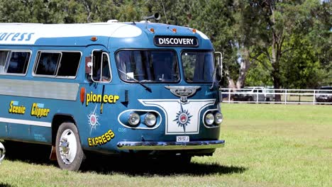 old-fashioned bus moving through a sunny field