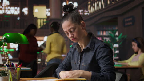 mujer estudiando en una biblioteca
