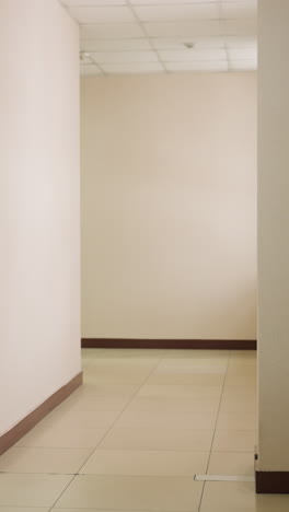 confident businesswoman walking down office hallway in formal suit holding red notebook, heading toward meeting room with glass door, bright modern corporate interior, professional atmosphere