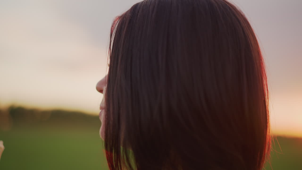 Caucasian woman eating banana in meadow profile shot with sunset rim light, slow living mood, side view portrait, braid and soft hair silhouette, quiet savoring and mindful chewing, pastoral horizon