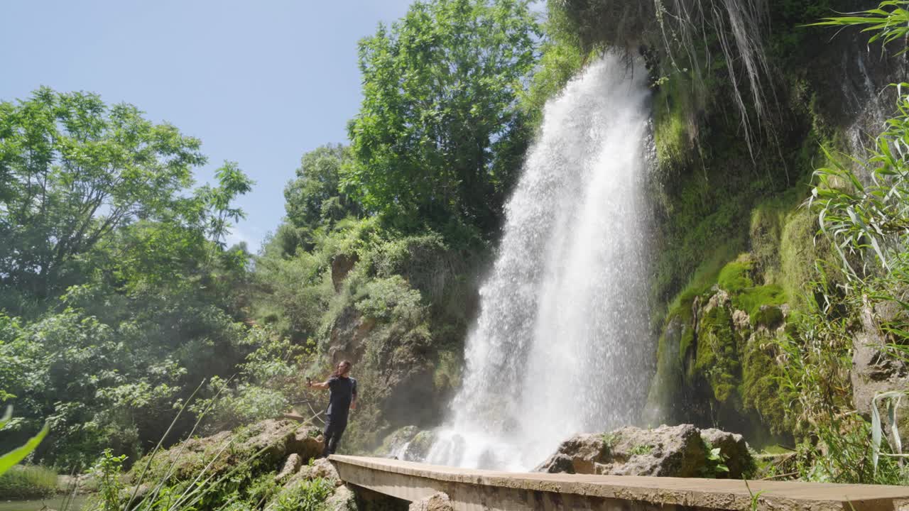 Waterfall Scene with Person on Bridge