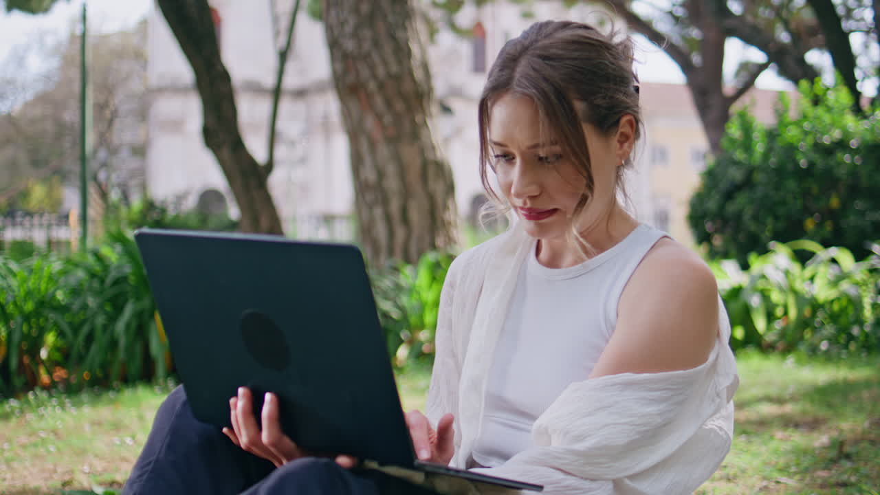 Woman typing laptop park sitting at green grass closeup. freelancer