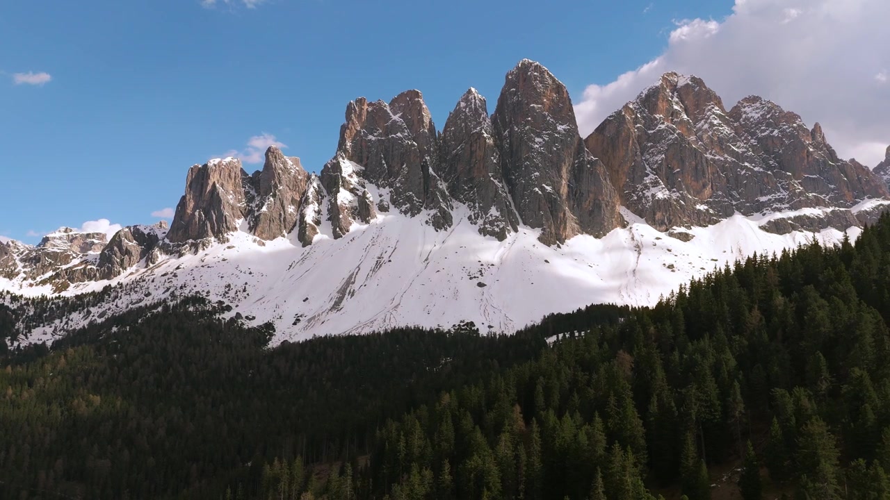 Panorerende luftfoto af Puez-Geisler Naturpark med alpin fyrreskov og sne ved Odle-bjergene