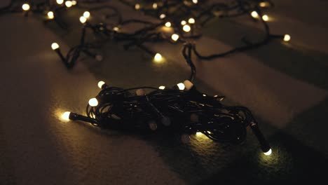 close-up de hank de la guirlanda de navidad con luces doradas en un playd. concepto de navidad. decoración del hogar