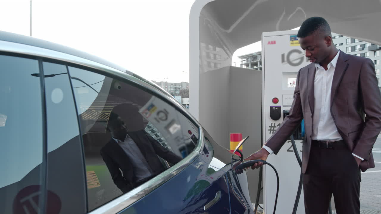 hombre cargando un vehículo eléctrico en la estación