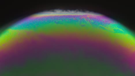 Macro-Of-Soap-Bubble-With-An-Iridescent-Surface-In-Black-Background