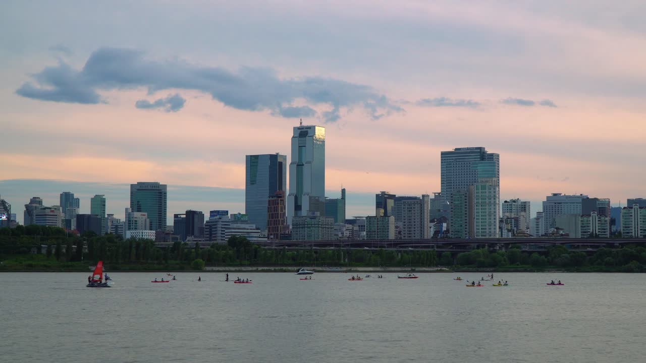 한국 서울 잠실 지구의 한강 너머 무역탑, 유리탑, 아셈타워 등 도시 타워의 극적인 일몰 전망