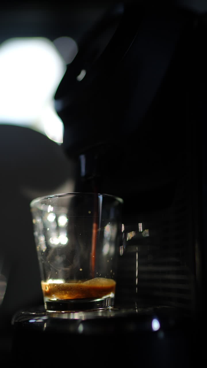 Espresso che si versa in una tazza di vetro trasparente