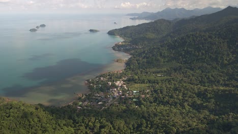 aerial footage of island with dense tropical forest with ocean and island and small village on koh chang