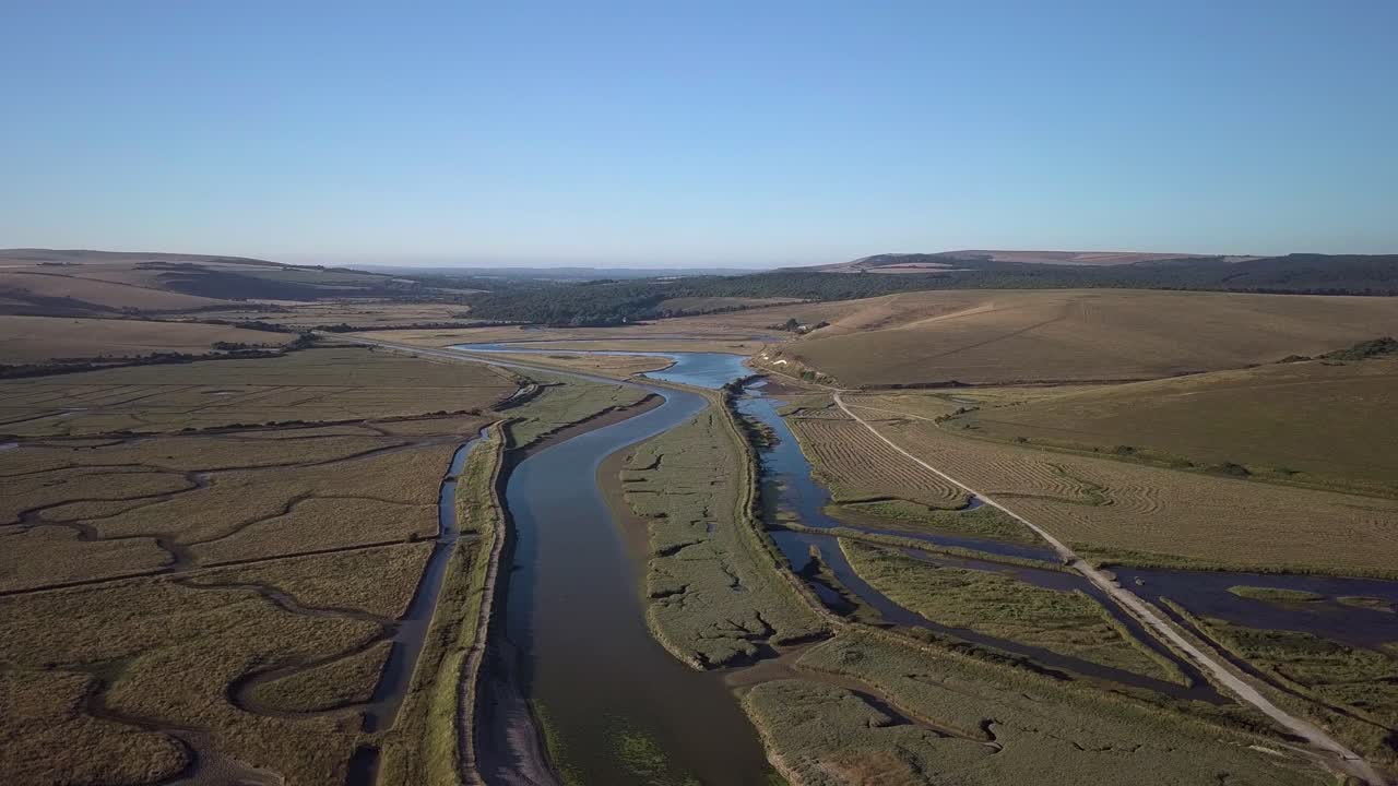 scenario potente che si innalza più in alto nel cielo guardando dall'alto in basso su una natura colline che sono state allagate vicino alla spiaggia sguardo neutro nessuno intorno al sentiero a piedi e colore della vegetazione sbiadita
