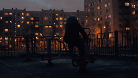 kid on street exercise bike in the dusk