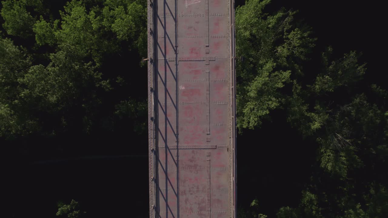 Old iron bridge over forest treetops. Aerial top view. Bridge over forest from a bird's eye view. High-rise steel viaduct over forest. Durcal. Spain