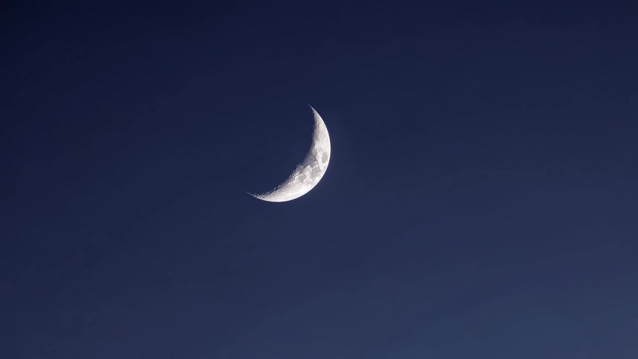 Lua crescente brilhando no céu noturno escuro.