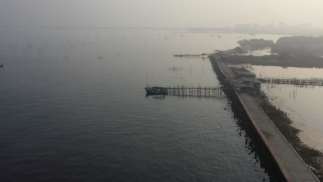 foggy coastal landscape with fishing boats and structures