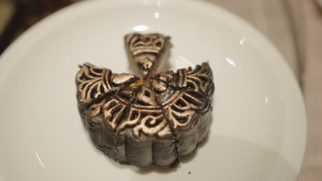 person cutting a decorated mooncake